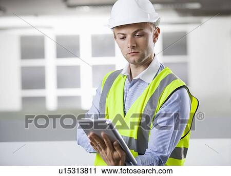 Young Caucasian architect using digital tablet at office View Large Photo Image Stock Image - Young Caucasian architect using digital tablet at office. Fotosearch
