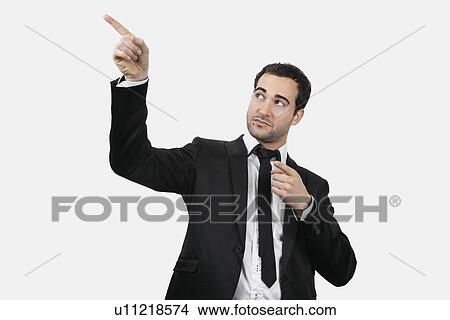 Picture - Young Caucasian businessman pointing upwards against white background. Fotosearch