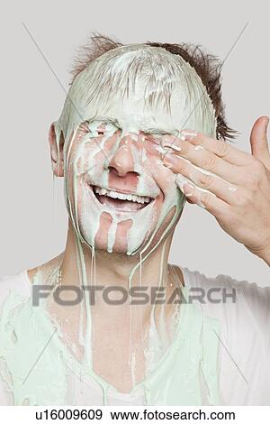 Young Caucasian man covered with paint wiping his eyes against gray background View Large Photo Image Stock Photo - Young Caucasian man covered with paint wiping his eyes against gray background. Fotosearch