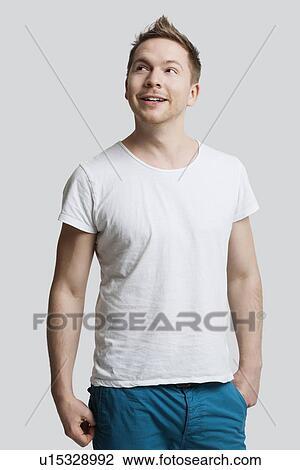 Young Caucasian man in casuals looking away against white background View Large Photo Image Stock Image - Young Caucasian man in casuals looking away against white background. Fotosearch