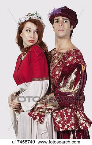 Young couple in periodic costumes against gray background View Large Photo Image Stock Photo - Young couple in periodic costumes against gray background. Fotosearch