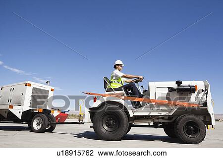 Young male ground crew driving truck at airport runway View Large Photo Image Stock Image - Young male ground crew driving truck at airport runway. Fotosearch