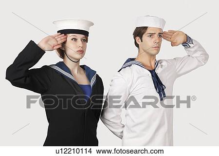 Young man and woman in sailor's uniform saluting against gray background View Large Photo Image Picture - Young man and woman in sailor's uniform saluting against gray background. Fotosearch