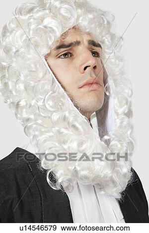 Stock Photo - Young man dressed as judge against gray background. Fotosearch