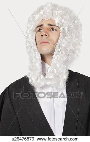 Young man dressed as judge looking away over gray background View Large Photo Image Stock Photo - Young man dressed as judge looking away over gray background. Fotosearch