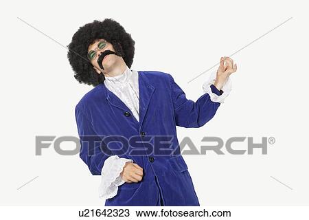 Young man in blue coat playing air guitar against gray background View Large Photo Image Stock Image - Young man in blue coat playing air guitar against gray background. Fotosearch