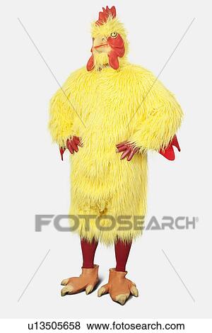 Young man in chicken suit standing with hands on hips against gray background View Large Photo Image Stock Photo - Young man in chicken suit standing with hands on hips against gray background. Fotosearch