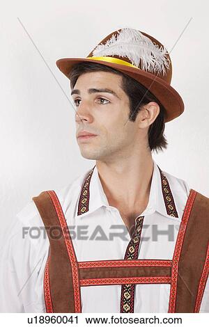 Young man in costume looking away against gray background View Large Photo Image Stock Image - Young man in costume looking away against gray background. Fotosearch
