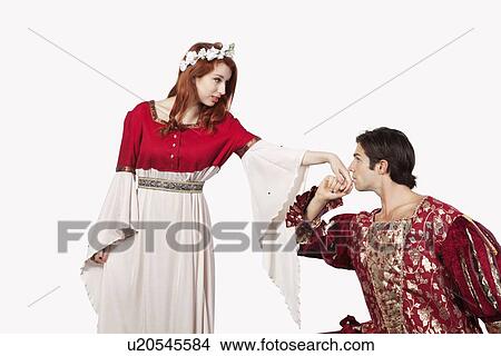 Young man in old-fashioned costume kissing princess's hand against gray background View Large Photo Image Picture - Young man in old-fashioned costume kissing princess's hand against gray background. Fotosearch