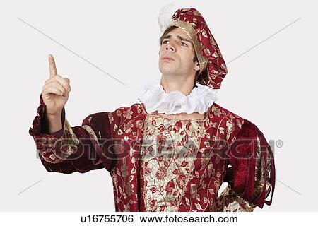 Stock Photograph - Young man in old-fashioned costume gesturing against gray background. Fotosearch