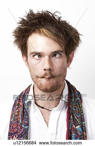 Young man making funny faces against white background View Large Photo Image Picture - Young man making funny faces against white background. Fotosearch
