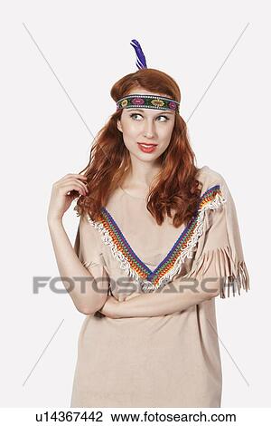 Stock Image - Young woman dressed in old-fashioned costume day dreaming against gray background. Fotosearch
