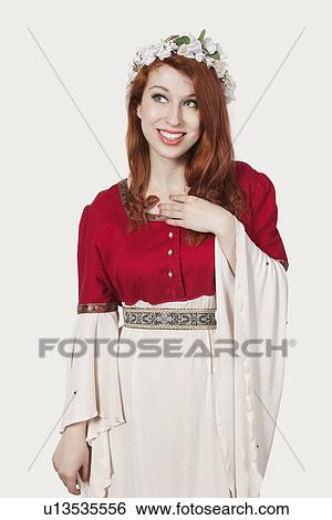 Young woman in old-fashioned princess costume looking away against gray background View Large Photo Image Stock Photograph - Young woman in old-fashioned princess costume looking away against gray background. Fotosearch