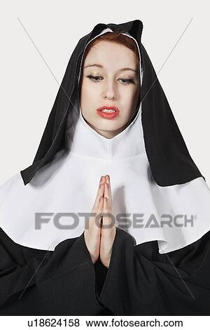Young woman with in nun costume praying against gray background View Large Photo Image Stock Photo - Young woman with in nun costume praying against gray background. Fotosearch