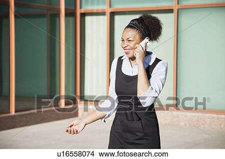 Cheerful young woman in formals using mobile phone View Large Photo Image Picture - Cheerful young woman in formals using mobile phone. Fotosearch