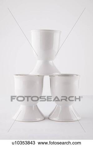 Stock Image - Close-up of empty egg cups arranged against white background. Fotosearch