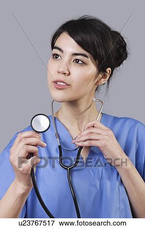 Close-up of mixed race female surgeon looking up over gray background View Large Photo Image Stock Photo - Close-up of mixed race female surgeon looking up over gray background. Fotosearch