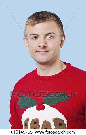 Close-up portrait of young man in sweater against blue background View Large Photo Image Stock Photography - Close-up portrait of young man in sweater against blue background. Fotosearch