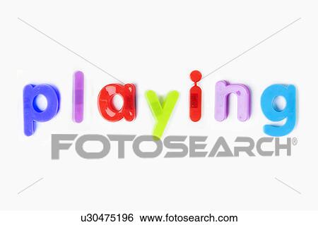Stock Photograph - Colorful alphabet magnets spelling 'playing' over white background. Fotosearch