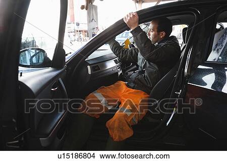 Employee wiping vehicle windscreen in car wash View Large Photo Image Picture - Employee wiping vehicle windscreen in car wash. Fotosearch