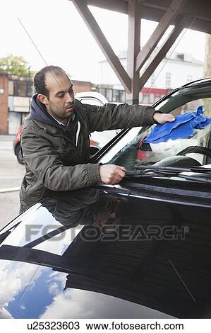 Employee wiping vehicle windscreen in car wash View Large Photo Image Stock Image - Employee wiping vehicle windscreen in car wash. Fotosearch