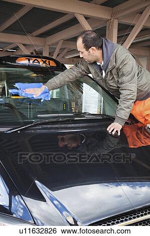 Employee wiping vehicle windscreen in car wash View Large Photo Image Stock Photograph - Employee wiping vehicle windscreen in car wash. Fotosearch