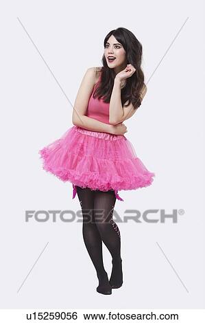 Stock Photograph - Full length of mixed race young woman looking away over white background. Fotosearch
