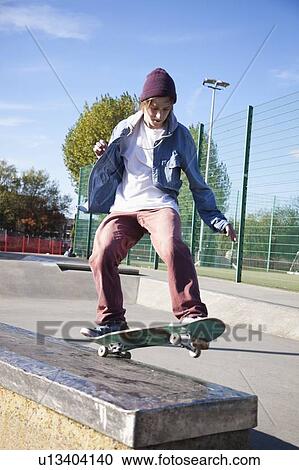 Low angle view of young man skateboarding View Large Photo Image Stock Image - Low angle view of young man skateboarding. Fotosearch