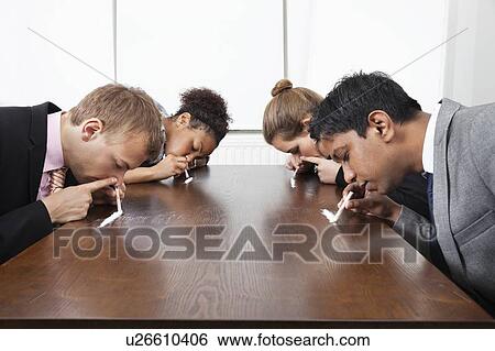 Multiethnic business people sniffing cocaine around conference table View Large Photo Image Stock Photograph - Multiethnic business people sniffing cocaine around conference table. Fotosearch