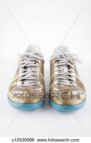 Pair of gold casual shoes over white background View Large Photo Image Stock Photograph - Pair of gold casual shoes over white background. Fotosearch