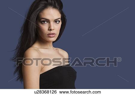 Portrait of beautiful young woman in tube bra over blue background View Large Photo Image Stock Photograph - Portrait of beautiful young woman in tube bra over blue background. Fotosearch