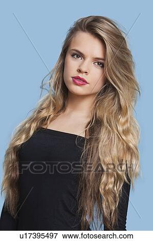 Portrait of beautiful young woman over blue background View Large Photo Image Stock Photo - Portrait of beautiful young woman over blue background. Fotosearch