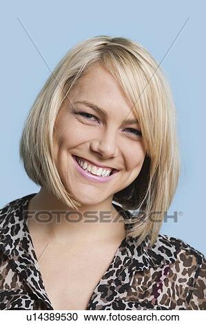 Portrait of beautiful young woman smiling over blue background View Large Photo Image Stock Image - Portrait of beautiful young woman smiling over blue background. Fotosearch