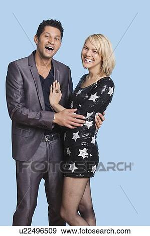 Portrait of cheerful couple against blue background View Large Photo Image Stock Photo - Portrait of cheerful couple against blue background. Fotosearch