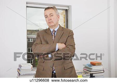 Portrait of confident businessman with arms crossed in office View Large Photo Image Stock Photo - Portrait of confident businessman with arms crossed in office. Fotosearch