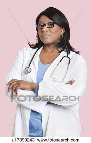 Portrait of confident mixed race female surgeon over pink background View Large Photo Image Stock Image - Portrait of confident mixed race female surgeon over pink background. Fotosearch