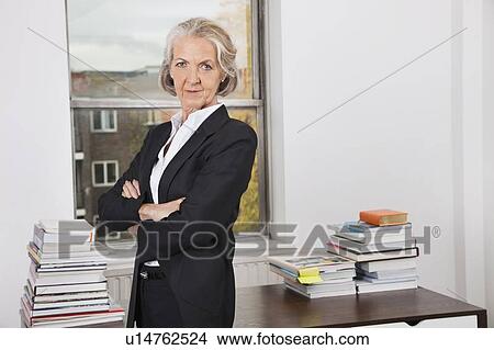 Portrait of confident senior businesswoman with arms crossed in office View Large Photo Image Picture - Portrait of confident senior businesswoman with arms crossed in office. Fotosearch