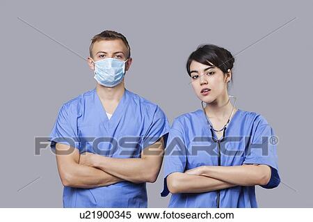 Portrait of female and male surgeons standing with arms crossed over gray background View Large Photo Image Stock Photography - Portrait of female and male surgeons standing with arms crossed over gray background. Fotosearch