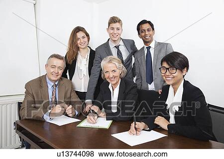 Stock Photo - Portrait of happy multiethnic professionals meeting in office. Fotosearch