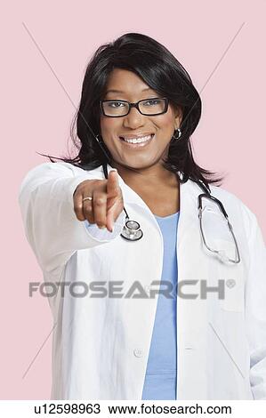 Portrait of mixed race female surgeon pointing at you over pink background View Large Photo Image Stock Image - Portrait of mixed race female surgeon pointing at you over pink background. Fotosearch