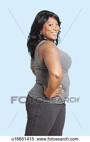 Portrait of mixed race woman with hand on hip exercising over blue background View Large Photo Image Stock Photography - Portrait of mixed race woman with hand on hip exercising over blue background. Fotosearch