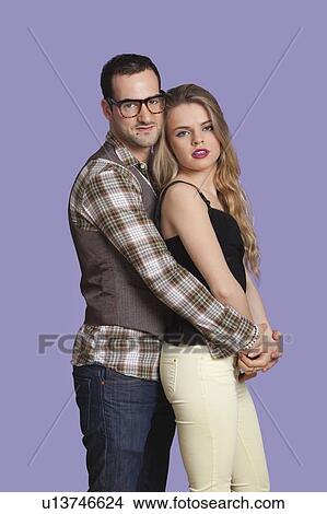Portrait of romantic young couple against purple background View Large Photo Image Picture - Portrait of romantic young couple against purple background. Fotosearch