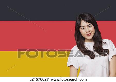 Portrait of smiling mixed race young woman against German flag View Large Photo Image Stock Photo - Portrait of smiling mixed race young woman against German flag. Fotosearch