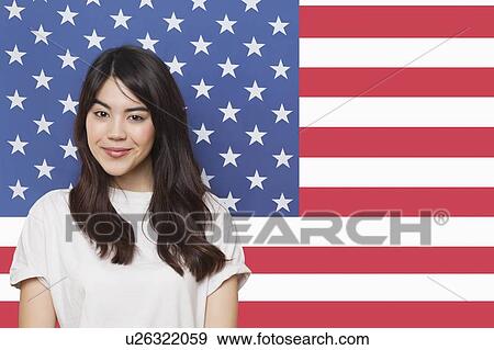Portrait of smiling mixed race young woman against American flag View Large Photo Image Stock Photo - Portrait of smiling mixed race young woman against American flag. Fotosearch