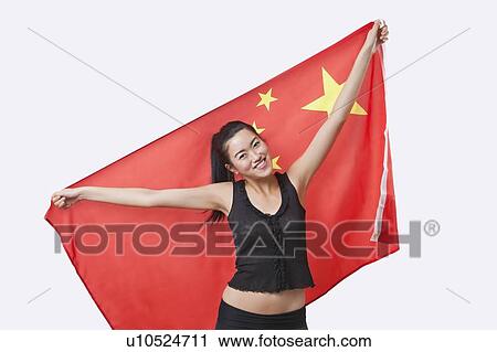 Portrait of smiling young woman holding Chinese flag over white background View Large Photo Image Stock Image - Portrait of smiling young woman holding Chinese flag over white background. Fotosearch