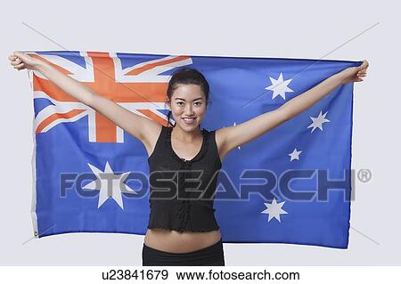Portrait of smiling young woman holding Australian flag over white background View Large Photo Image Stock Photo - Portrait of smiling young woman holding Australian flag over white background. Fotosearch