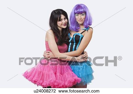 Portrait of two beautiful young woman embracing each other over white background View Large Photo Image Stock Image - Portrait of two beautiful young woman embracing each other over white background. Fotosearch