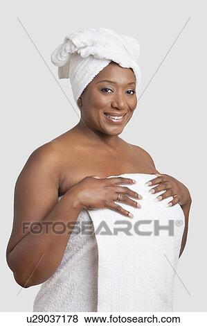 Stock Photo - Portrait of woman with body and head wrapped in towels over white background. Fotosearch