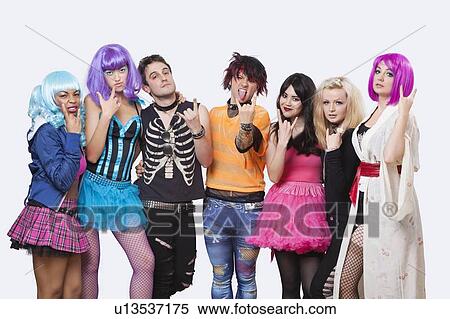 Stock Photography - Portrait of young punk group gesturing rock & roll hand signs over white background. Fotosearch