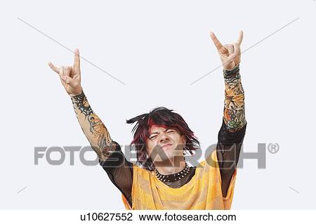 Portrait of young punk man gesturing rock & roll hand sign over white background View Large Photo Image Stock Image - Portrait of young punk man gesturing rock & roll hand sign over white background. Fotosearch
